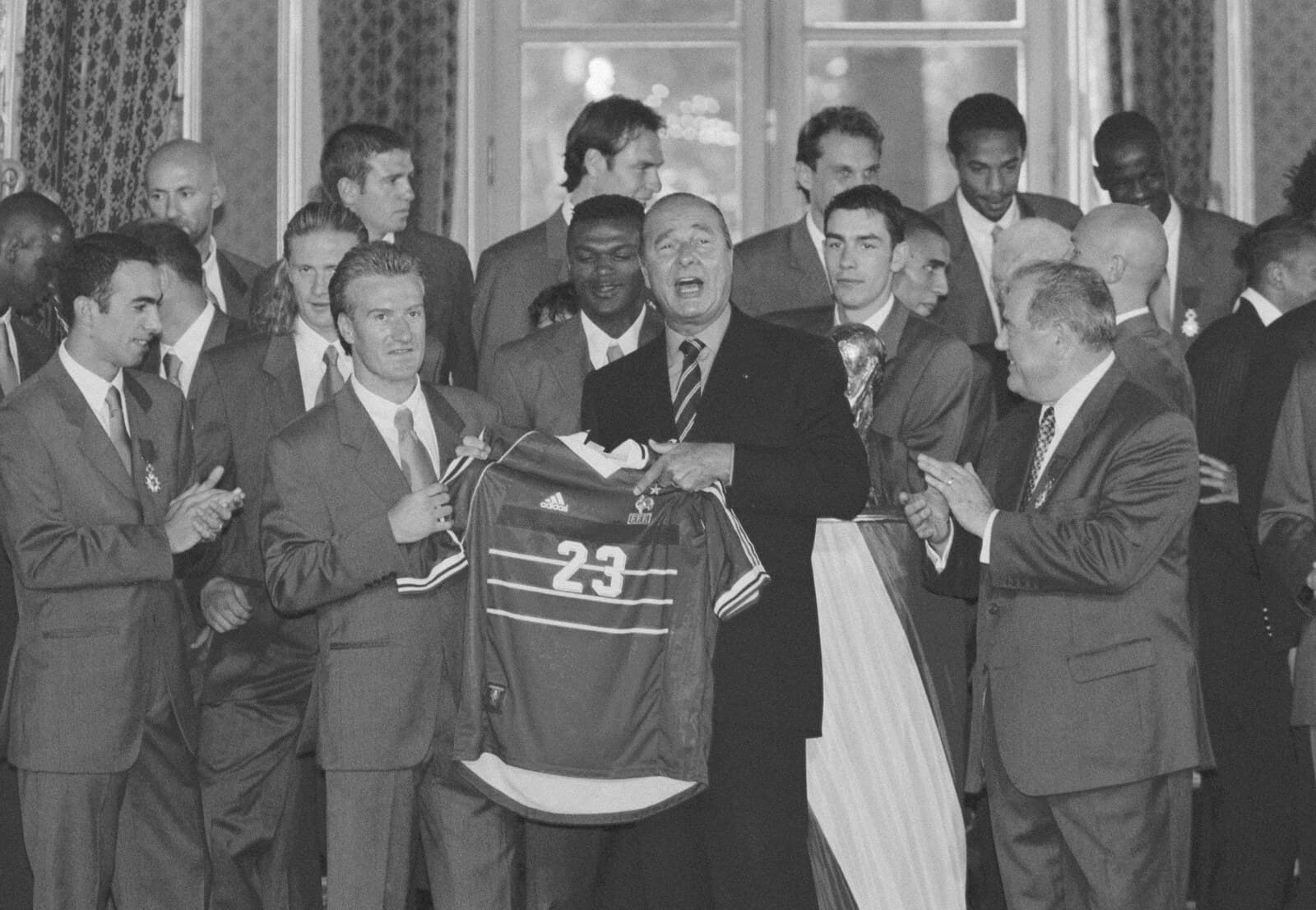 Didier Deschamps présente un maillot des Bleus avec Jacques Chirac lors de la réception des champions du monde 1998 à l'Élysée, le trophée visible à droite